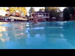 Boys playing in swimming pool with action camera