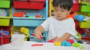 Child is sculpting with modeling clay.Asian kids play with clay molding shapes, learning through play.