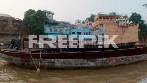 Cinematic people gather Ganges River cruise chowk canal boat Varanasi Northern India State Ancient Holy city Khidkiya Ghat Pradesh Provinc landscape gray cloudy still calm muddy brown pan right motion | Premium Stock Video Footage
