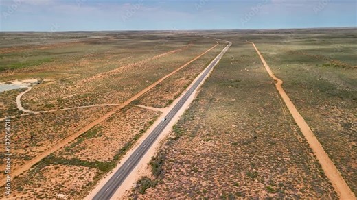 Exmouth road aerial view revealing iconic termite mounds dotting arid outback landscape Western Australia highway