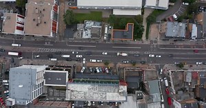 Aerial Birds Eye Overhead Top Down Descending View of Vehicles Driving on Street in City