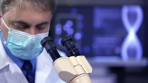 Chemist looking inside microscope in the lab