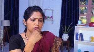 A middle-aged Indian woman in thinking mode - sitting alone difficult decision loneliness financial problem. A young woman in her early thirties is facing problems in life - stressful life str...