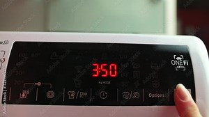 Close-up of washing machine control panel with user adjusting showcasing modern appliance features and user interaction setting washing machine timer control panel washing machine