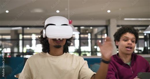 Diverse friends watching VR user donning headset, testing demo, friend showing tablet on campus
