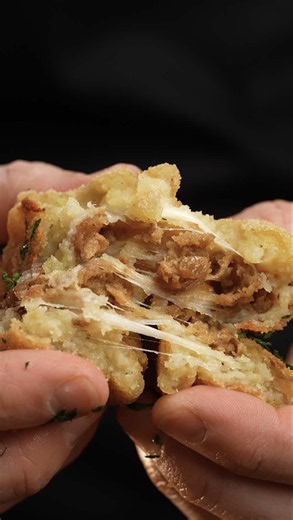 Gefüllte Kartoffelbällchen Das brauchst du Für die Kartoffelmasse: 700 g mehligkochende Kartoffeln 50 g Speisestärke 1/2 TL Zwiebelpulver 1 TL Salz 1/2 TL schwarzer Pfeffer 1/4 TL Muskat Für die Füllung: 100 g Snack Balls (v) 120 g Streukäse (v) Für die Panade: 80 g Mehl 150 ml Kochsahne (v) 150 g Paniermehl Außerdem: 2 EL Öl zum Backen 10g (eine Handvoll) Petersilie 1/2 TL schwarzer Pfeffer 1/2 TL Salzflocken So machst du es 1.⁠ ⁠Die Kartoffeln in grobe Stücke schneiden und in Salzwasser 25 Min