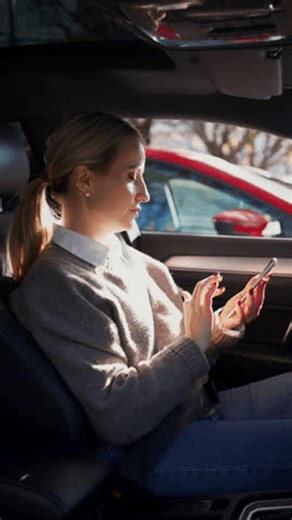 clip-3988332837-female-driver-using-phone-while-waiting-traffic