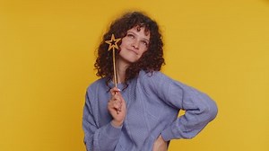 Magician witch woman gesturing with magic wand fairy stick, making wish come true, casting magician spell, advertising holidays sale discount. Young teen girl isolated on yellow studio background