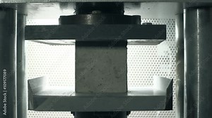 Concrete brick pressure test. Cracks covering the brick under pressure. Slow motion close up shot.