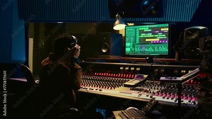 African american sound designer removing tonal imbalances and white noise on recorded files, music industry post production in professional studio. Control room expert editing tracks. Camera B.