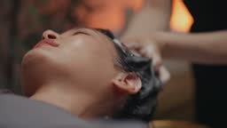 Woman relaxing during a luxurious hair wash and head spa session at a...