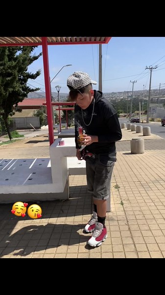 Individual at Bus Stop Enjoying a Beverage