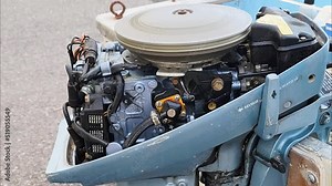 Small Outboard Boat Motor Test Without Cover on Land. Engine Running and Spinning while Water Splashes. Mechanical Maintenance - close up