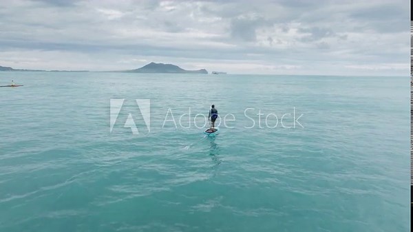 Water sports on Oahu, Hawaii island. Surfer wake boarding on foil board. Athletic man rides a foilboard by using power of ocean waves. Water sport activity. Extreme sport activity shot on drone camera