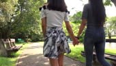 lesbian couple walking together in public park