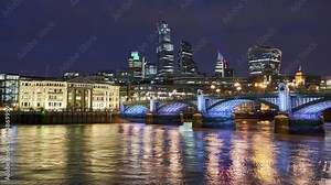 City of London skyline timelapse including 22 Bishopsgate, Walkie Talkie and other modern skyscrapers at night with the illuminated Southwark bridge in the foreground. England, UK