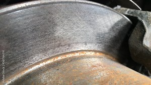 Diagnosis and inspection of the car's rusty brake discs at the service station. Check the residual size of the brake pads on the brake disc.