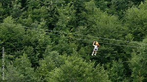 Woman moving on zip line. Woman moves on zip line above the canyon
