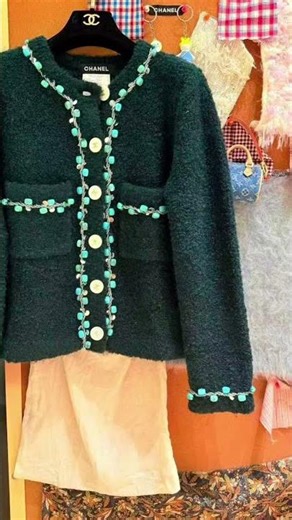 A textured dark green Chanel-style jacket adorned with turquoise beaded trim and white buttons.