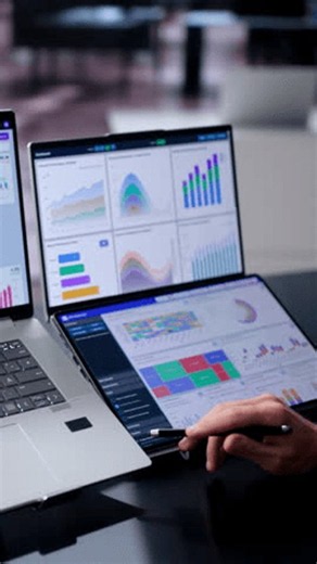 clip-4144118249-data-analyst-reviews-financial-dashboards-on-dual