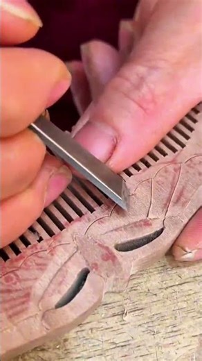 carving the wooden surface to create a butterfly pattern using a professional manual chisel tool