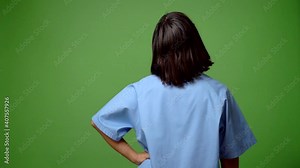 Woman with nurse uniform pointing back with the index finger