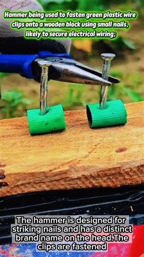 Hammer being used to fasten green plastic wire clips onto a wooden block using small nails.