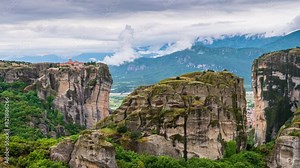 Hyper lapse with moving low clouds over holy Trinity monastery on cliff in Meteora, Thessaly Greece.
