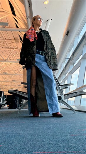 April Elizabeth | Style & Fashion & Body on Instagram: "Heading to New York with my little minions and yes, I wore a slit skirt with built-in panties on the plane. Why? Because bending, lifting, squatting, twisting — motherhood is a sport and this outfit is the uniform. Black tee (hide the stains). Thrifted bomber (oversized and fabulous). Red cowboy boots (so I don’t lose them when I inevitably kick them off). Hairpiece to disguise my “plane hair” because flights make me feel… dusty. Follow alo