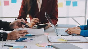 Two creative business people meeting and planning use post it notes sticky note on desk to share idea, Analysis data chart and graph with teamwork strategy brainstorming in office.