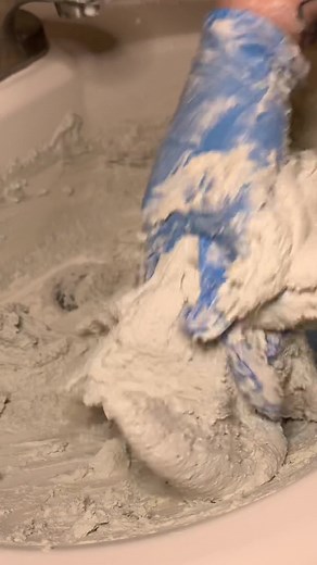 Hand Mixing Thick Paste in a Bathroom Setting