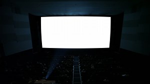 White cinema screen with projector light and audience