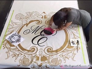 This is how we hand paint an ornately monogrammed Original Runner in one minute flat. We just love perfecting life’s Grand Entrances with our nonslip fabric aisle runners! | The Original Runner Company