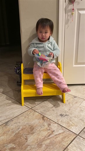 #life Cute daily life of holding a transparent candy box and sitting on a small yellow stool.