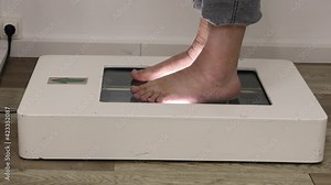 Foot scanning to determine exact size and feet form. Man using the electric device in a shoe store.