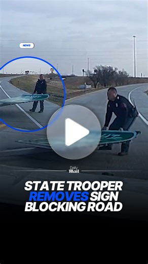 State trooper removes fallen exit sign from roadway