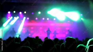 Beautiful lights illuminates the crowd at a rock band performance. Rock band on the stage at a festival.