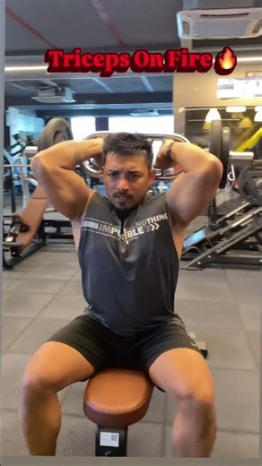 Overhead barbell press: great for long-head triceps growth. Keep elbows tight, core locked.”