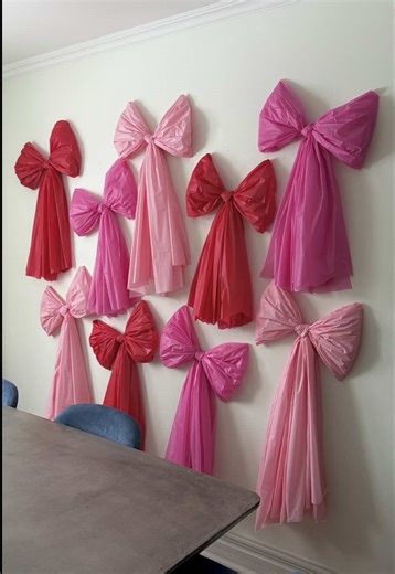 the perfect DIY valentine’s bow wall 🎀 I used plastic tablecloths from the dollar store, tied them into a bows, fluffed them up, and hung them using glue dots. Such an easy affordable DIY that makes a big impact. #diybows #bowdecor #valentinesdecor #diyvalentine #valentinesinspo