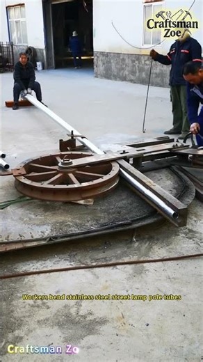 Workers bend stainless steel street lamp pole tubes