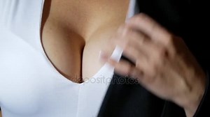 A woman with a beautiful chest puts on a black jacket