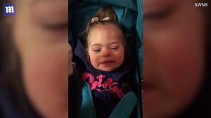 Siblings with Down Syndrome happily play in stroller