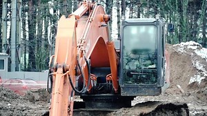 Loader backhoe, excavator digging a trench. Clip. Work of excavating machine on building construction site. Excavator digs a hole