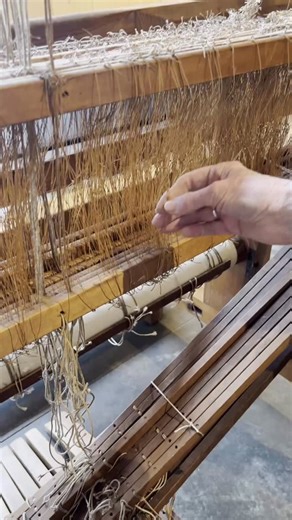 Jenny Kilbride explains the treadle mechanism on the loom once owned by Ethel Mairet. The treadle is the foot-operated system that lifts and lowers the heddles, allowing pattern to emerge while both hands remain free to throw the shuttle. On looms like this, pattern is created through rhythm and movement — a working process central to Mairet’s approach to craft. #ditchling #craft #weaving #loom #treadles | Ditchling Museum of Art Craft