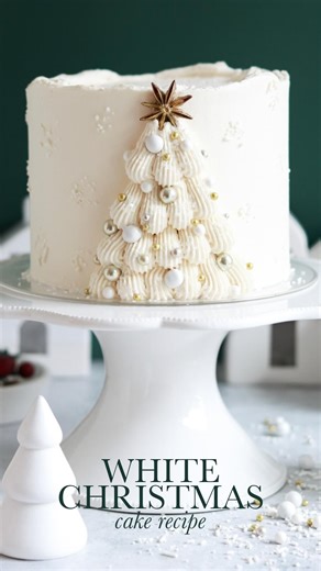 WHITE CHRISTMAS CAKE 🤍🎄I’ve been dreaming of this white Christmas cake since last year finally turned my softest, fluffiest white cake recipe into a holiday showstopper! My favorite part is the gold anise star on top of that pretty piped Christmas tree ✨ Full recipe (with frosting decorating tutorial) linked in my bio at https://sugarandsparrow.com/white-christmas-cake-recipe/ ⁣ 🎄Piping tip: @wiltoncakes tip 4B 🤍Sprinkles: @sprinklepop.shop “Wedding Bells” mix white sanding sugar ⭐️Star: ani