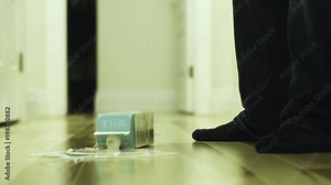 A milk carton drops to the floor and spills.