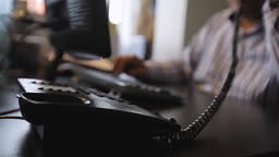 Operator picking up the phone for answering the questions, Office...