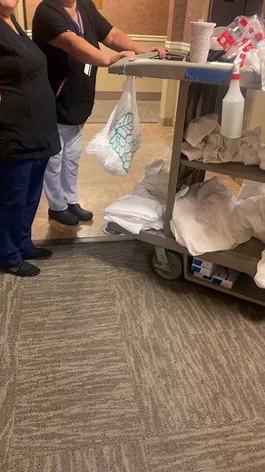 Healthcare Workers Handling Supplies in Hospital Corridor