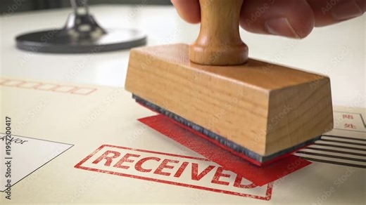 Aligning right hand then lowering wooden stamp onto desk form, pressing and leaving RECEIVED mark