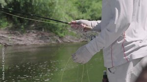 Fisherman stripping in some line while fly fishing in slow motion